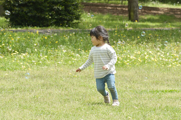 芝生の上を走る子ども