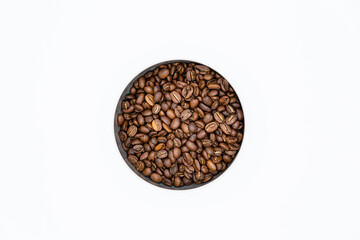 Mixture of different kinds of roasted coffee beans in white container on white background. Top view and copy space.