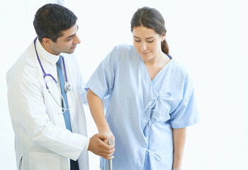 Fototapeta premium Doctor helped the female patient to walk on crutches.