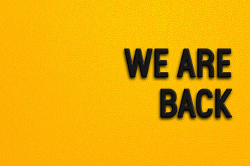 We are back - words on yellow background