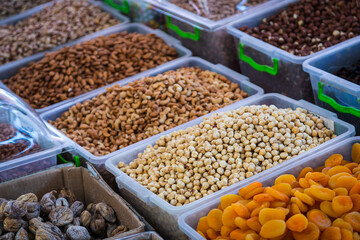 Close-up of beautiful rows of fresh nuts: shelled hazelnuts, cashews, almonds, figs, raisins, dried...