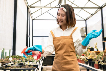 Beautiful woman using a red spray bottle containing compost or natural extracts help prevent insect...
