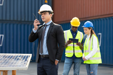 male factory worker or engineer using walkie talkie for preparing a job in containers warehouse storage