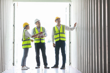 Obraz premium factory workers or engineers exploring inside container in warehouse storage