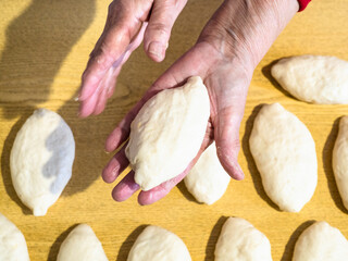 Fototapeta na wymiar cooked pie lies on palm above prepared pies