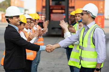Obraz na płótnie Canvas boss engineer shaking hands together with factory workers for congratulations work in containers warehouse storage