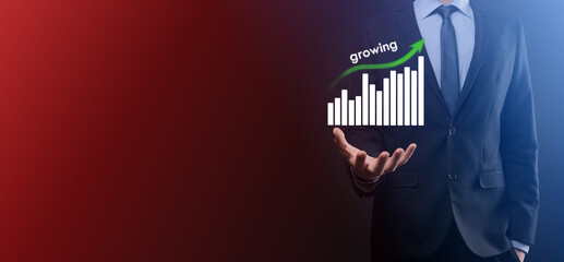 Business man holding holographic graphs and stock market statistics gain profits. Concept of growth planning and business strategy. Display of good economy form digital screen.