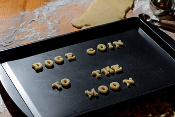 Plaque à biscuit avec écriture en anglais avec de la pâte à biscuit fraichement préparée en forme de lettre avec une expression populaire au sujet de la crypto monnaie  jusqu'à la lune - Powered by Adobe