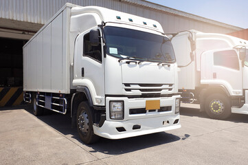 Container Truck Parked Loading at Dock Warehouse. Cargo Shipment. Industry Freight Truck Transportation. Shipping Warehouse Logistics.