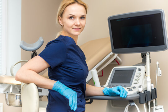 gynecologist sits at the ultrasound machine and smiles