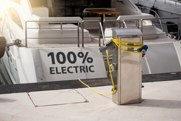 100% electric yacht is charged from the charging station in the marina