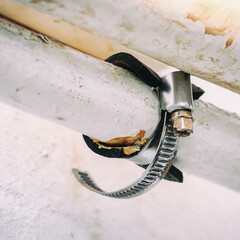 Clamp on white leaky water pipe