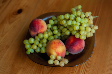 Fruit concept. Peach and green grapes on wooden background. Top view.