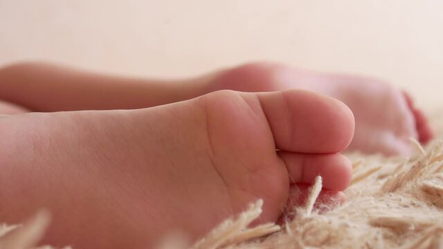 Close-up of the feet of a boy fidgeting on a soft fleecy blanket