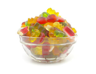 Heap of different gummy candies in glass bowl isolated on white background