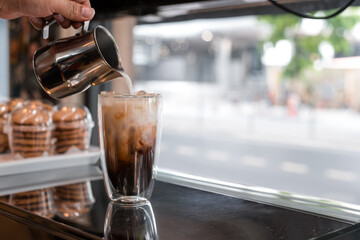 Close-up of iced coffee served on black table at cafe​