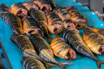 Pieces of smoked mackerel lie on a conveyor belt. Fish food factory.