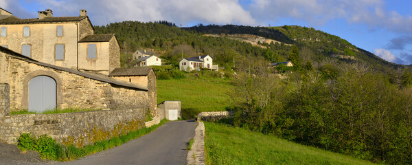Fototapeta na wymiar Panoramique arrière montagneux et verdoyant du village Le Pompidou (48110) , département de la Lozère en région Occitanie, France