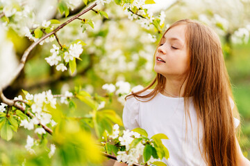 Beautiful teenage girl with a branch of a flowering tree. natural cosmetics