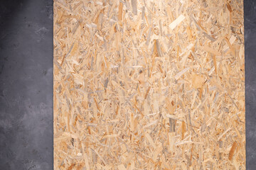 Wood osb background texture at concrete floor. Wooden chipboard at wall background