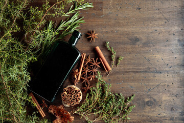 Vintage bottle, herbs, and spices on an old wooden table.