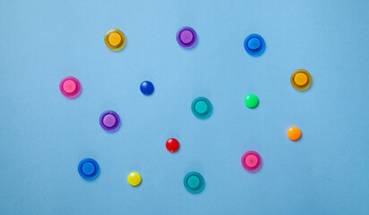 Colorful magnet plastic buttons on blue background.