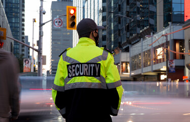Fototapeta premium Security guard patrolling&nbsp;busy street and city before sunset time.