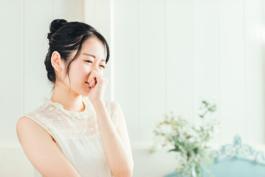 鼻をおさえる女性
