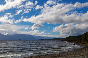 Lake Te Anau in Southland, New Zealand, the second largest lake in the country, with a sky full of fluffy white clouds above
