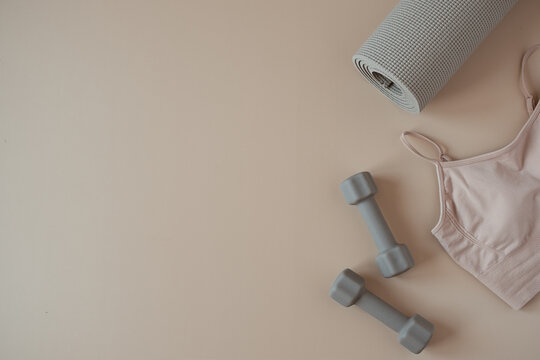 Aesthetic Creative Flat Lay Of Yoga, Fitness, Workout Training Equipment On Neutral Beige Background. Dumbbells, Top, Mat. Flatlay, Top View Sport Influencer Concept