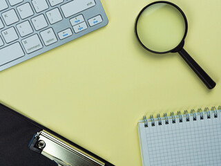 Top view above of yellow workplace with keyboard and notepad. Copy space for your text, Flat lay. Office work and office conception.