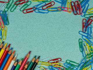School conception, colorful school paper clips and multicolored pencils on a blue background. Copy space. Back to school. Flatlay, top view.