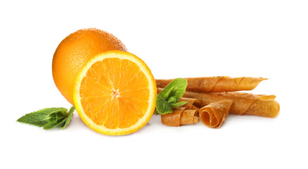 Delicious fruit leather rolls, mint and oranges on white background