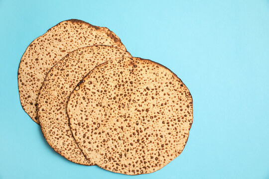 Tasty matzos on light blue background, flat lay. Passover (Pesach) celebration