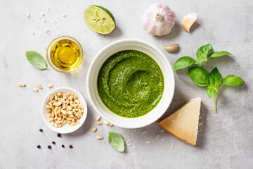 Fresh Italian pesto sauce with basil, pine nuts, parmesan cheese and olive oil on the light gray...