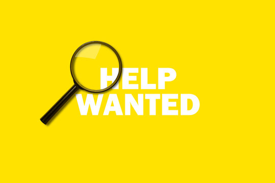 magnifying glass loupe on yellow background. Added Help Wanted sign