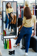 Fototapeta na wymiar Asian women in stylish shoes looking at mirror
