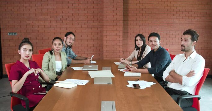 POV of A group of young, hard-working Asian employees male and female make conference video call for meeting in the conference room at warehouse offices and they agree with their client.