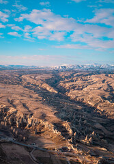 Beautiful vertical aerial view of the landscapes of Cappadocia, Turkey with fairy chimneys, mountains, rock formations and the town of Ürgüp