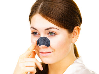Woman applying pore strips on nose