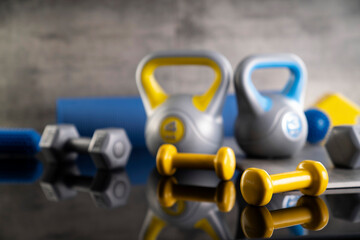 Fitness concept.  Equipment for fitness exercises: weighing machine and dumbbells. Gray background. 