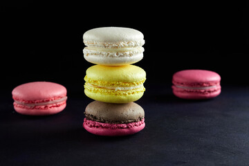 Sweet Macaron of different colors on an darke background.