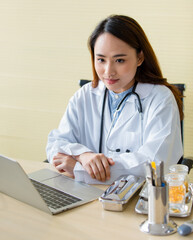 Young and beautiful Asian doctor pointing fingers to her head during doing history taking with the patient