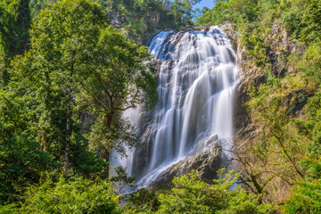 Fototapeta premium Khlong Lan Waterfall, large and exotic waterfall in tropical forest in National Park, Kamphaeng Phet, Thailand
