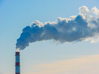 High chimney with thick smoke on the background of the sky.Factory smoke. Smoke pollution of the...