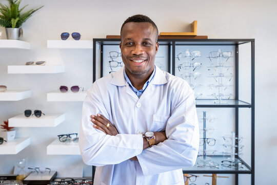 Portrait of African optician in optical shop store, cross arms, looking at camera. Eyecare concept.