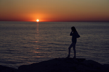 Fototapeta premium silhouette of a woman by the sea in the mountains in nature