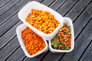 Freshly picked ripe Cloudberries, Rubus chamaemorus in white containers