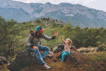 Family father and child daughter high five hands traveling in mountains hiking together summer...