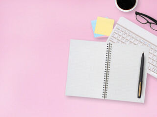 Top view office pink desktop with blank notebook and pen, stationery equipment with coffee cup. Business and education concept, space for your text..